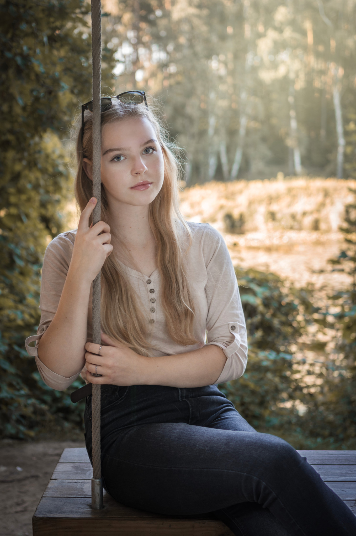 Klimatyczny portret plenerowy kobiety w jasnej bluzce, lifestylowe ujęcie z miękkim letnim światłem