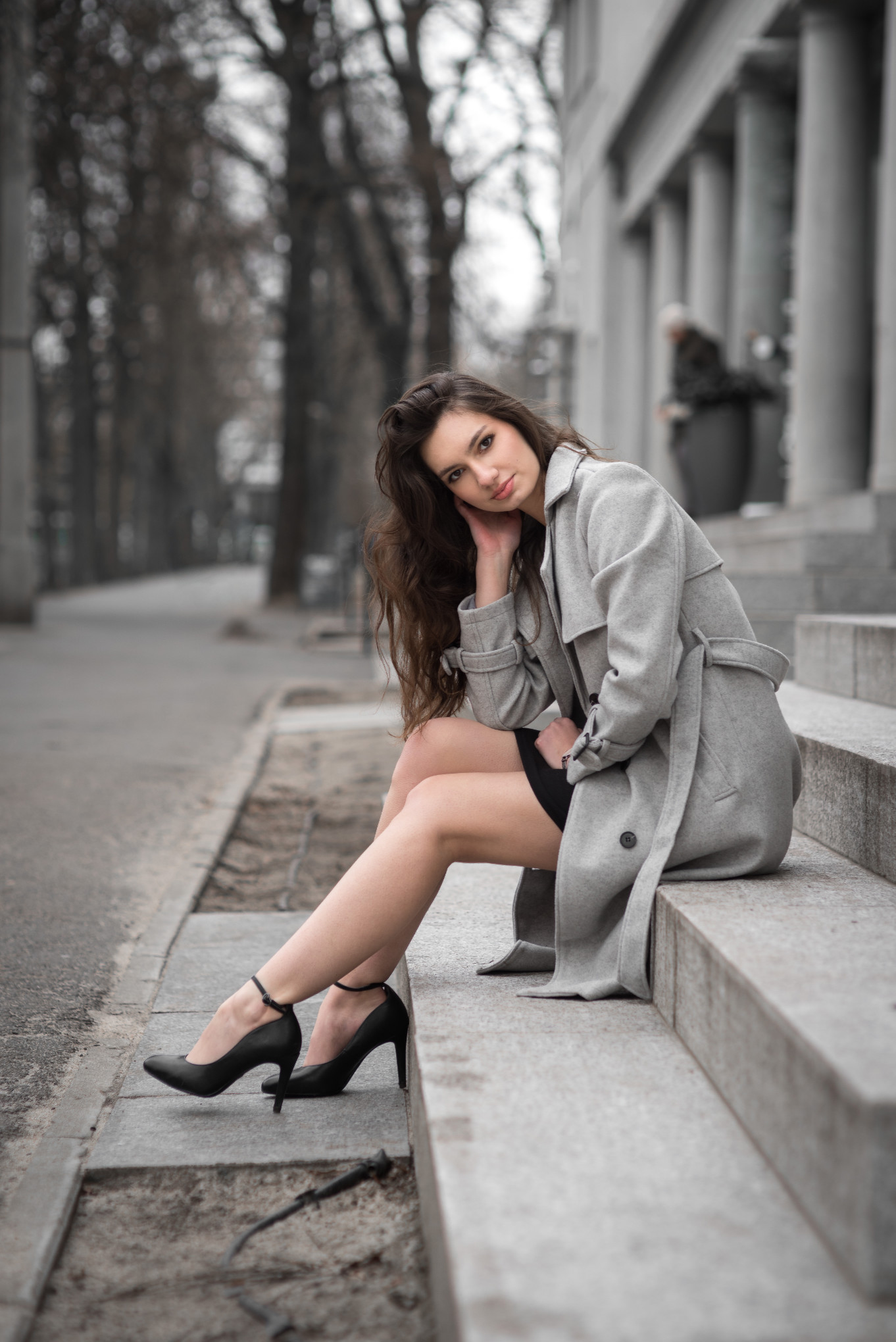Elegancka sesja kobieca – portret modelki w szarym płaszczu na schodach